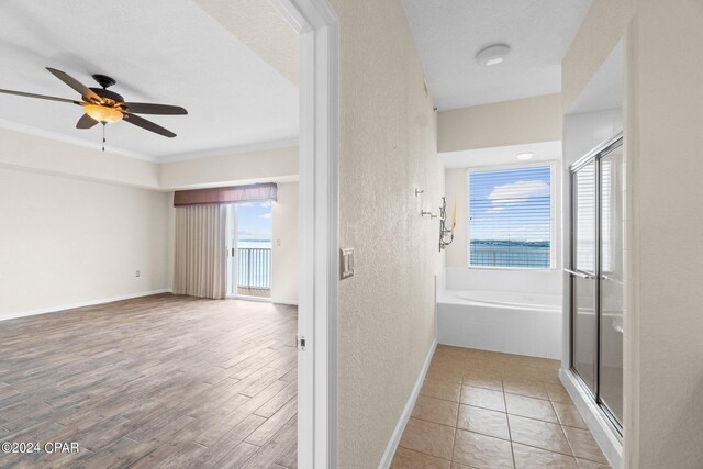 hall featuring a textured ceiling, crown molding, and light hardwood / wood-style flooring