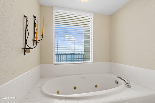 full bathroom featuring a textured wall and a whirlpool tub