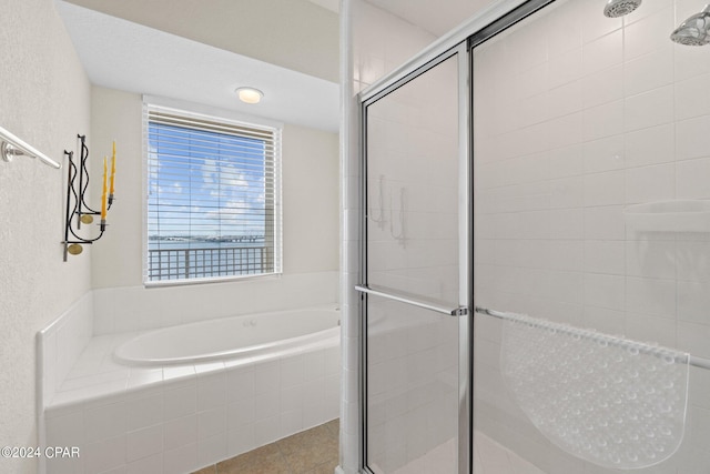 full bathroom with a garden tub, a shower stall, and tile patterned floors