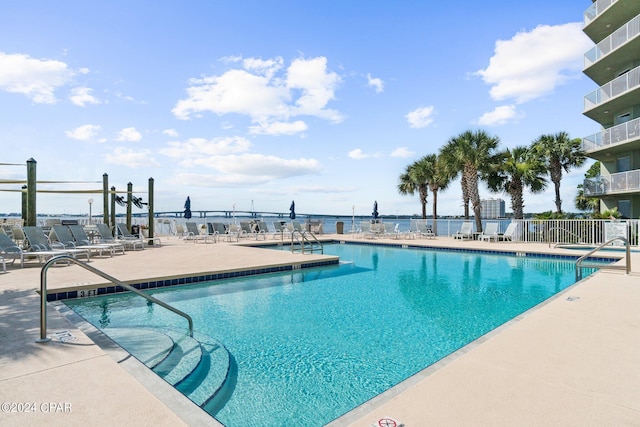 pool with a patio and fence