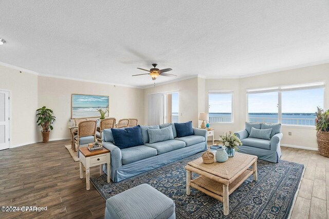 living room featuring wood-type flooring, a textured ceiling, a water view, and ornamental molding