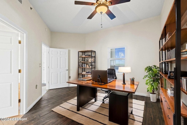 office space with dark wood-type flooring, a ceiling fan, and baseboards