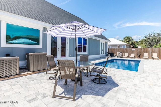 view of swimming pool featuring central AC, a patio area, and french doors