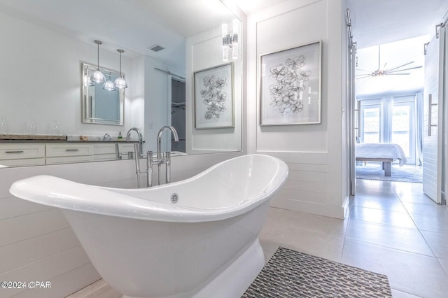 bathroom with tile patterned flooring, vanity, and a tub