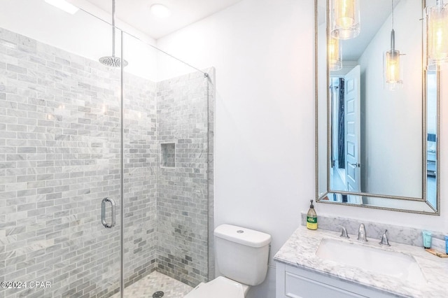 bathroom with a shower with door, vanity, and toilet