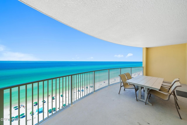 balcony featuring a beach view and a water view