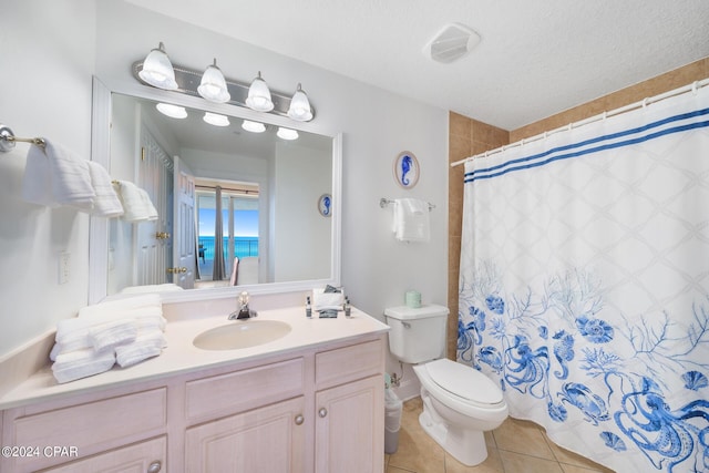 bathroom with walk in shower, vanity, a textured ceiling, tile patterned flooring, and toilet