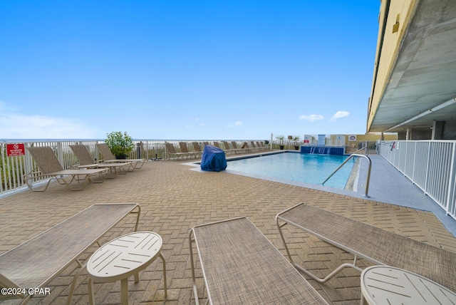 view of pool with a patio area and pool water feature