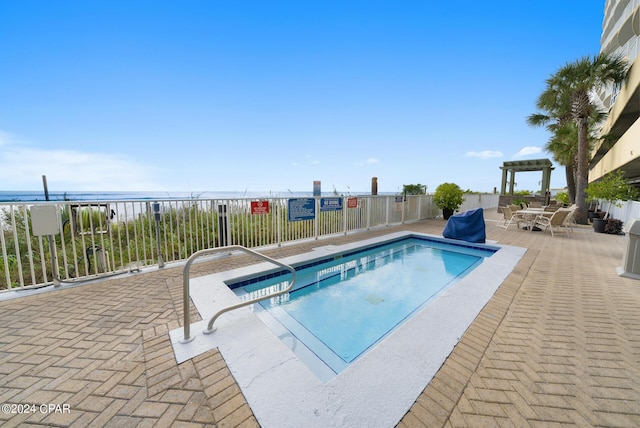 view of swimming pool with a water view and a patio