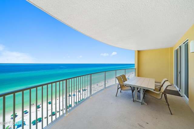 balcony featuring a water view and a beach view