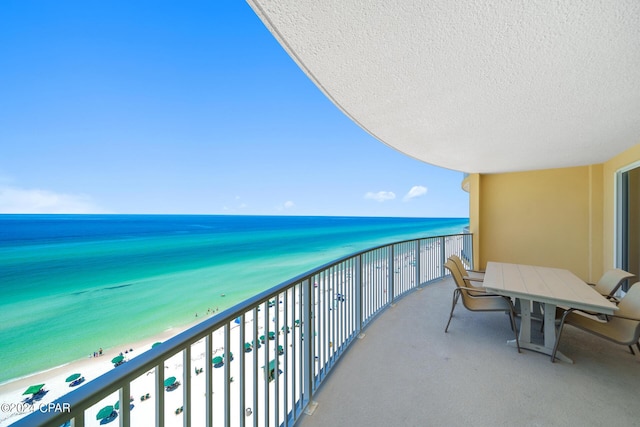 balcony featuring a water view and a view of the beach