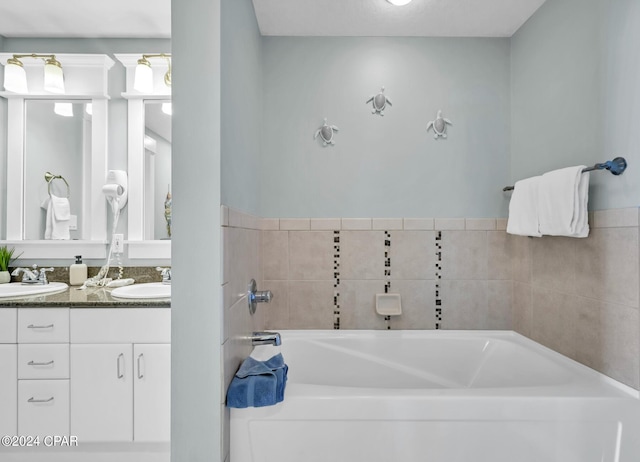 bathroom featuring double vanity, a garden tub, and a sink