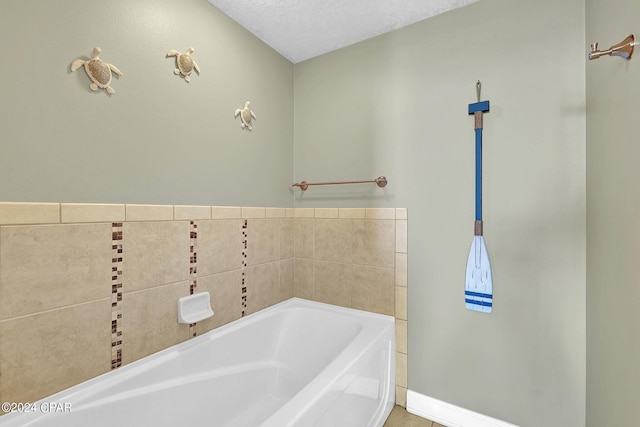 bathroom featuring a garden tub, a textured ceiling, and baseboards