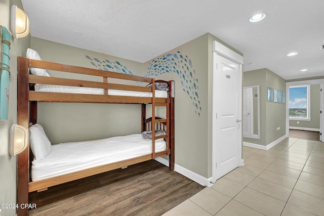 bedroom featuring recessed lighting, light tile patterned flooring, and baseboards