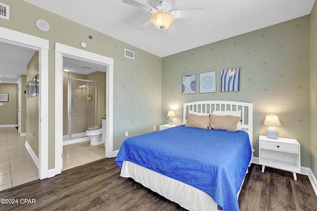 bedroom featuring connected bathroom, wood finished floors, visible vents, and baseboards