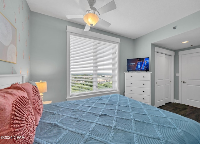 bedroom featuring dark wood-type flooring, a closet, and a ceiling fan