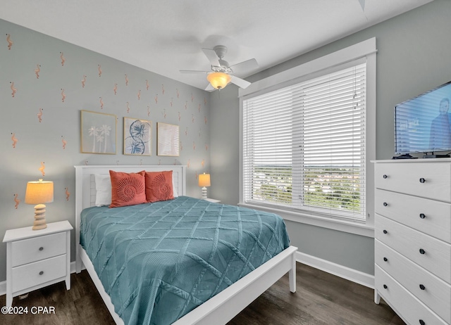 bedroom with ceiling fan, baseboards, and dark wood-type flooring