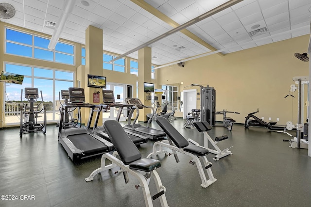 gym featuring a drop ceiling, visible vents, and a high ceiling