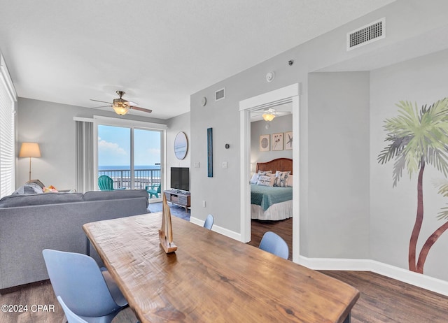 dining space with dark wood-type flooring, visible vents, baseboards, and a ceiling fan