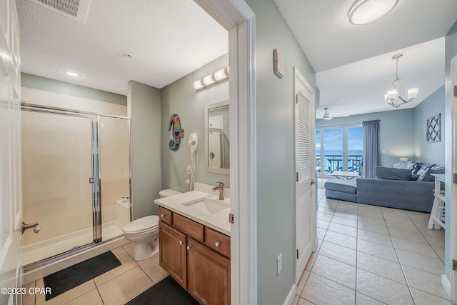 bathroom with walk in shower, toilet, a textured ceiling, vanity, and tile patterned flooring