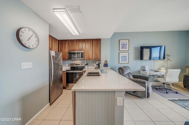 kitchen with light tile patterned flooring, appliances with stainless steel finishes, sink, and decorative backsplash