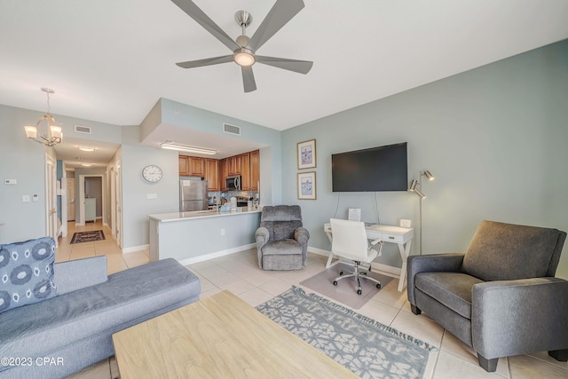 tiled living room featuring ceiling fan with notable chandelier