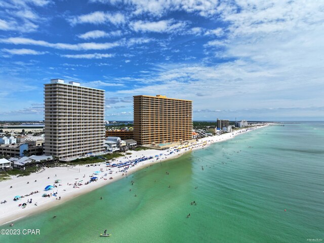 birds eye view of property featuring a water view and a beach view