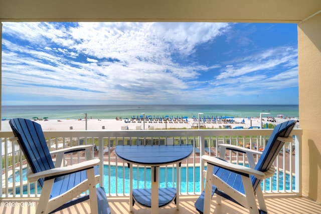 balcony featuring a water view and a beach view