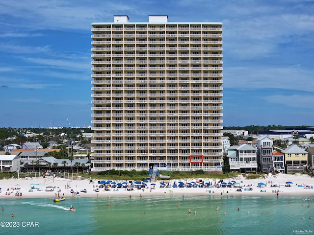 view of building exterior featuring a water view and a view of the beach