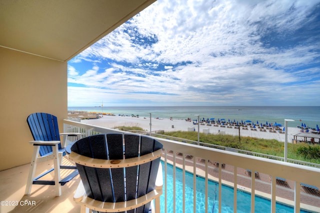 balcony with a water view and a beach view