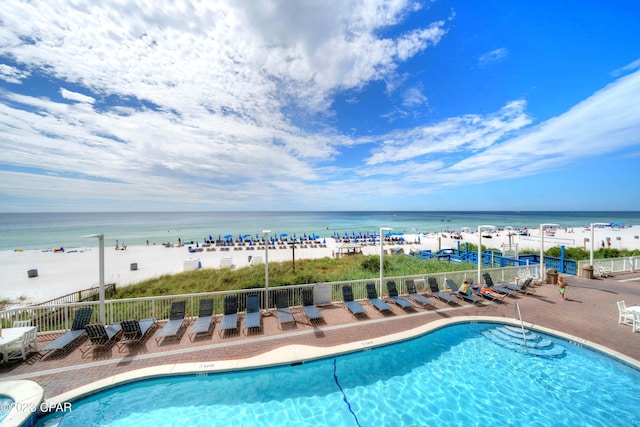 view of pool with a water view and a view of the beach