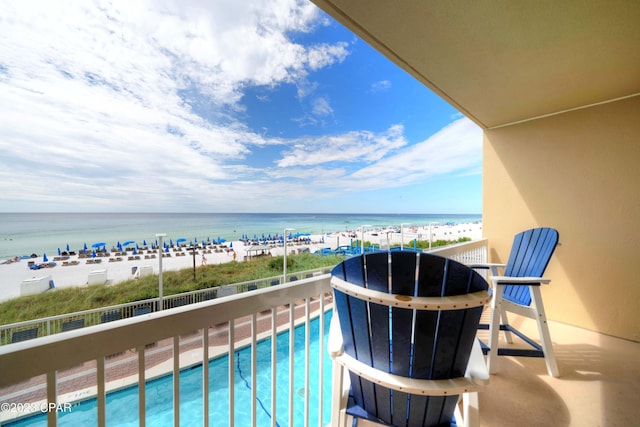 balcony featuring a beach view and a water view