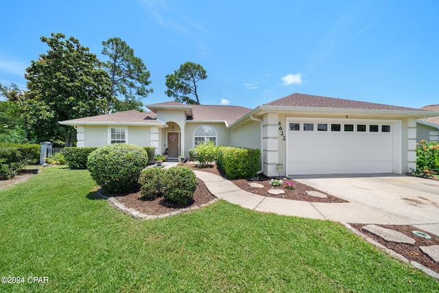 ranch-style home with a garage, a front lawn, driveway, and stucco siding