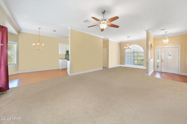 unfurnished living room with light carpet, ceiling fan with notable chandelier, and crown molding