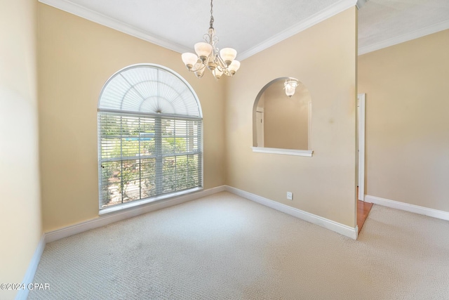 spare room with a notable chandelier, baseboards, crown molding, and carpet flooring