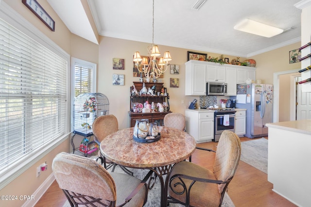 dining room with crown molding, light hardwood / wood-style floors, and an inviting chandelier