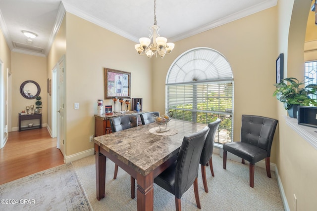 dining space with a chandelier, light wood-type flooring, crown molding, and a healthy amount of sunlight