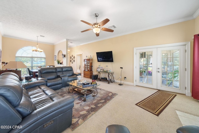 living room with carpet flooring, crown molding, french doors, and ceiling fan with notable chandelier