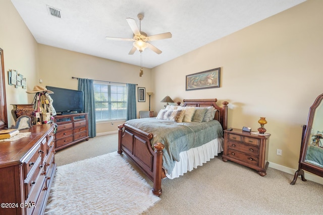 bedroom with light carpet, a ceiling fan, visible vents, and baseboards