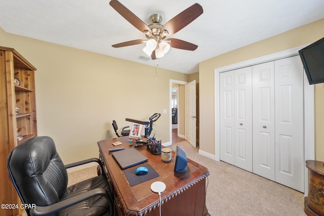 office space featuring light carpet and ceiling fan