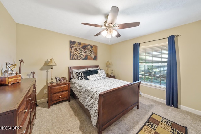 bedroom with a ceiling fan, baseboards, and light colored carpet