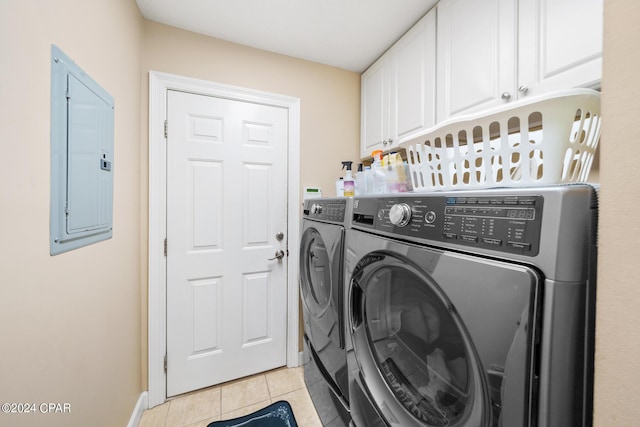 laundry area featuring separate washer and dryer, light tile patterned floors, electric panel, and cabinets