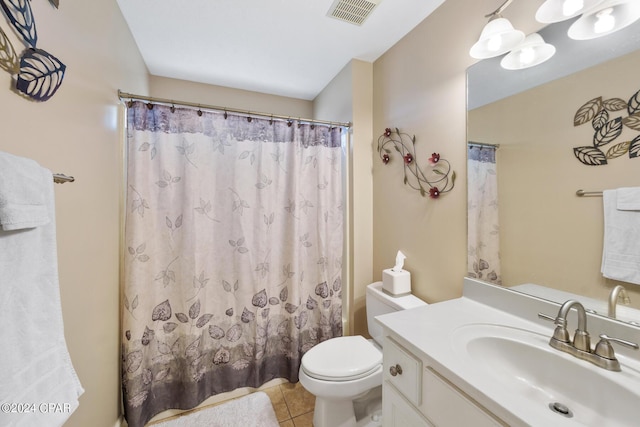 bathroom featuring tile patterned flooring, vanity, toilet, and walk in shower