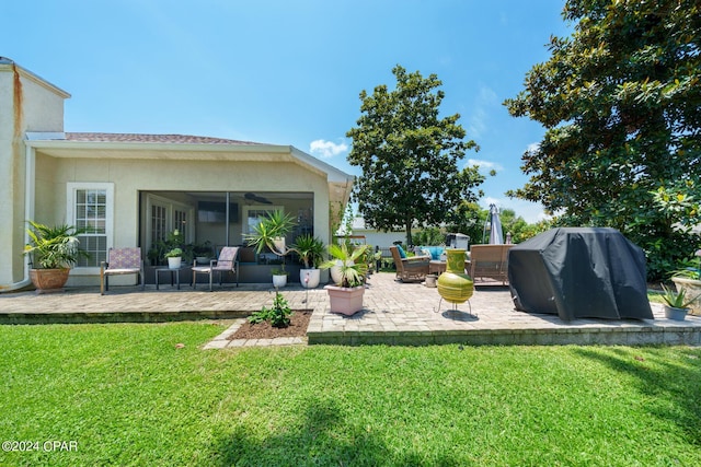 back of property featuring a lawn, a patio, stucco siding, and an outdoor living space