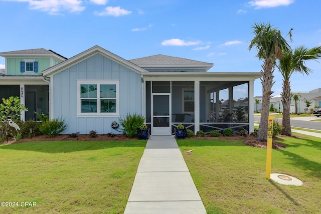 view of front of home with a front yard and a sunroom