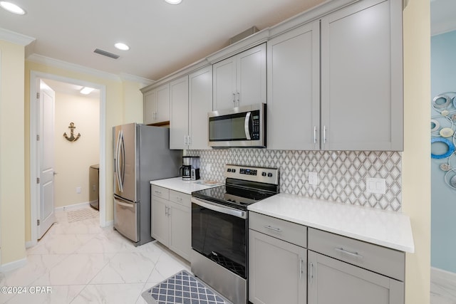 kitchen with crown molding, appliances with stainless steel finishes, gray cabinets, and backsplash