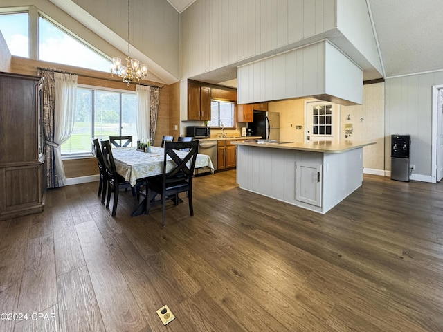 dining space featuring dark hardwood / wood-style flooring, sink, high vaulted ceiling, and a chandelier