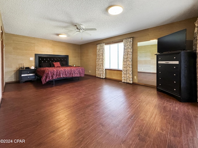 bedroom with ceiling fan, dark hardwood / wood-style flooring, and a textured ceiling