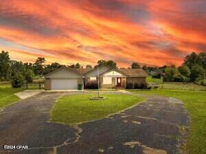 ranch-style home featuring a yard and a garage