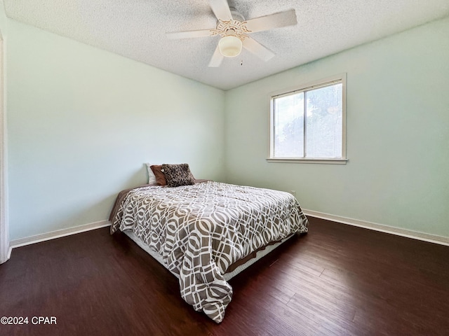 bedroom featuring a textured ceiling, ceiling fan, and dark wood-type flooring